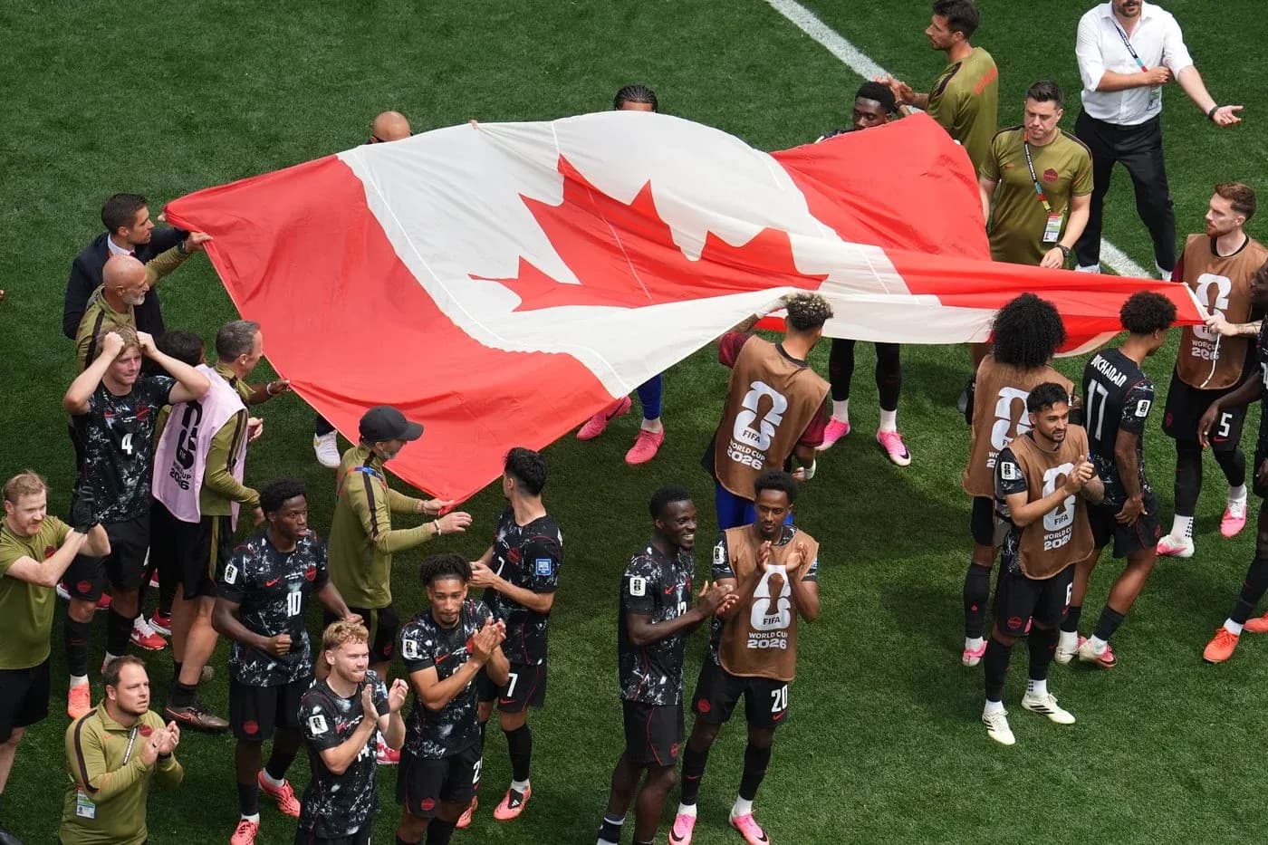 Jugadores de Canadá sosteniendo la bandera nacional Jugadores de Canadá sosteniendo la bandera nacional