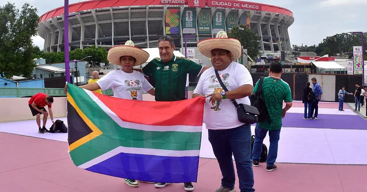 Aficionados sosteniendo bandera de Sudáfrica frente al estadio Aficionados sosteniendo bandera de Sudáfrica frente al estadio