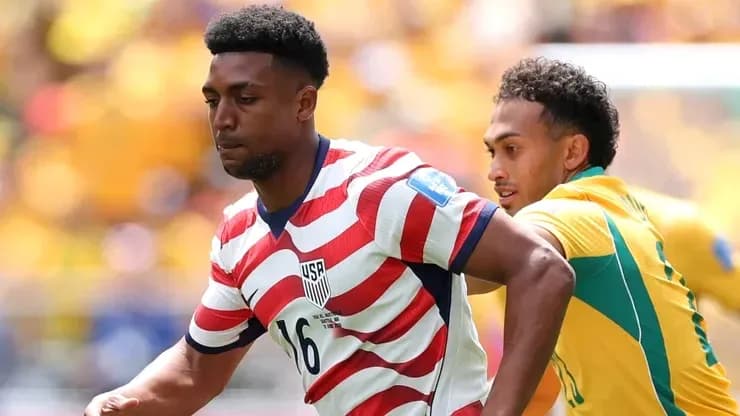 Jugador de Estados Unidos driblando a oponente durante partido Jugador de Estados Unidos driblando a oponente durante partido