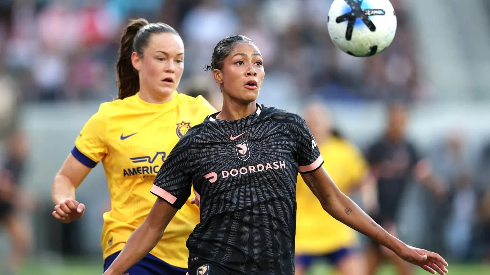 Jugadoras de fútbol compitiendo por el balón Jugadoras de fútbol compitiendo por el balón