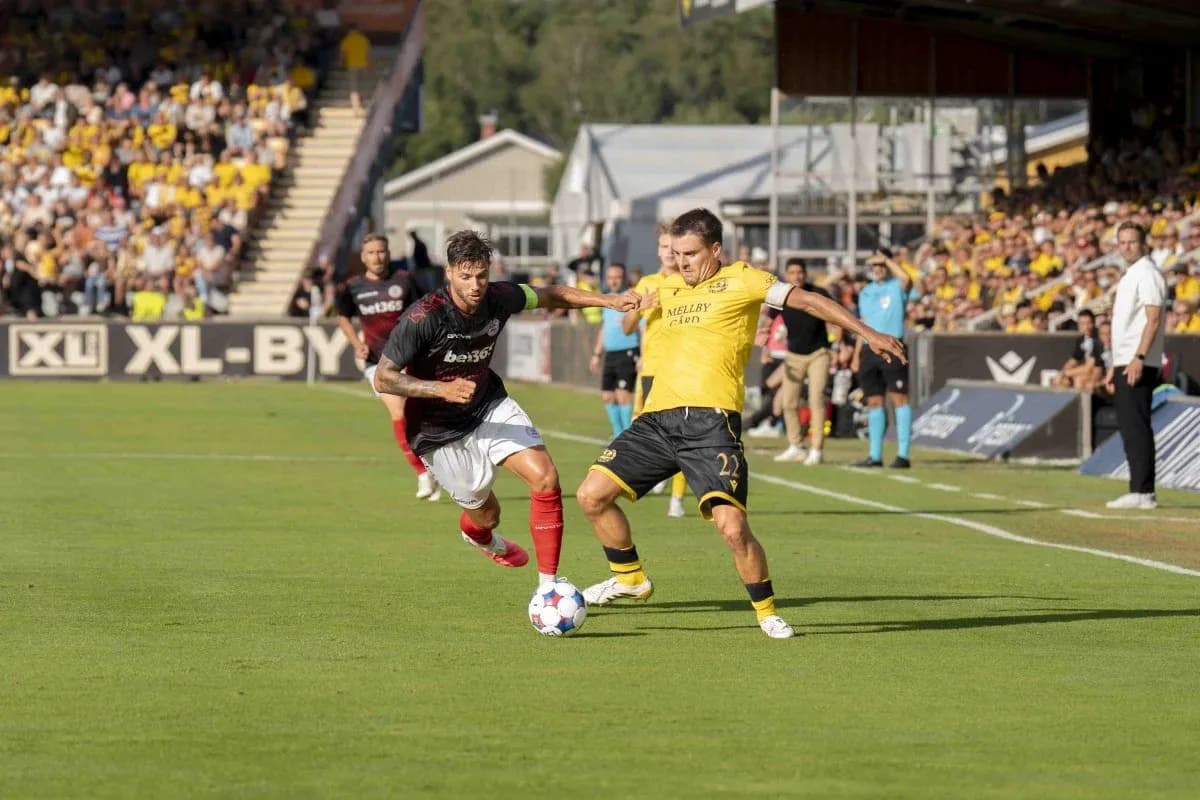 Dos jugadores compiten por el balón en el partido Dos jugadores compiten por el balón en el partido