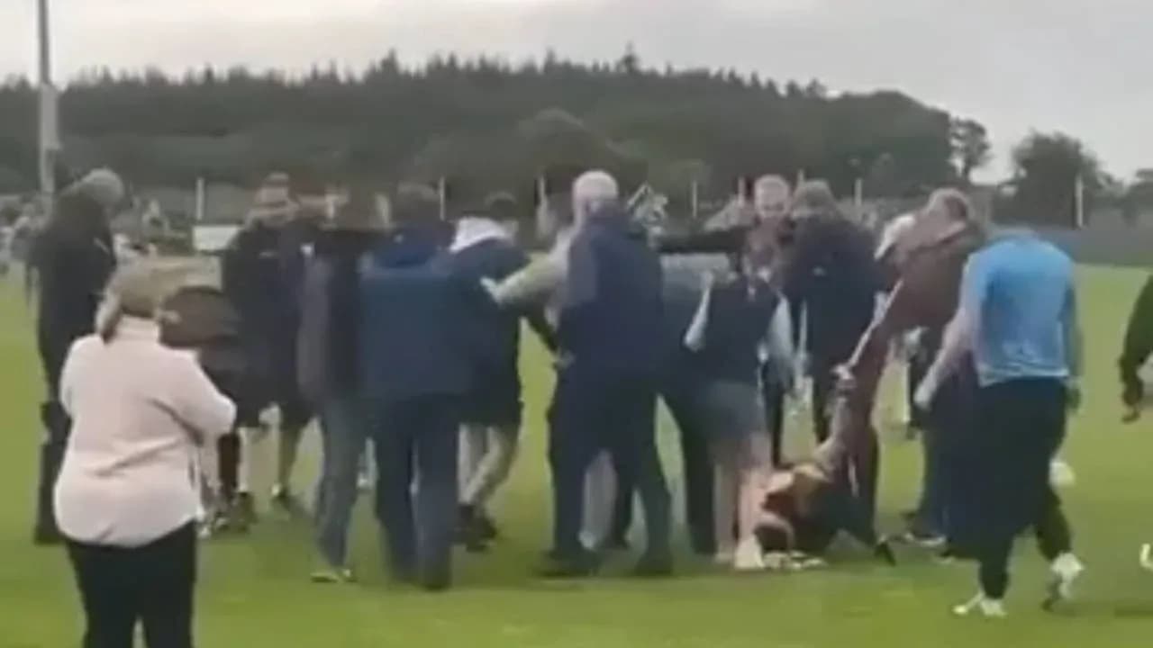 Multitud rodeando a jugadores en el campo de fútbol Multitud rodeando a jugadores en el campo de fútbol