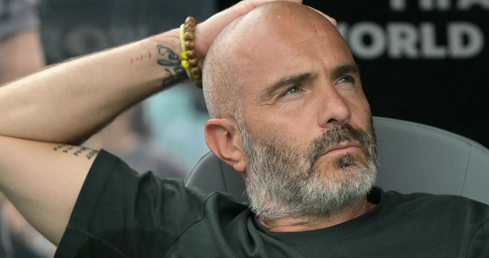Entrenador sentado con la mano en la cabeza Entrenador sentado con la mano en la cabeza