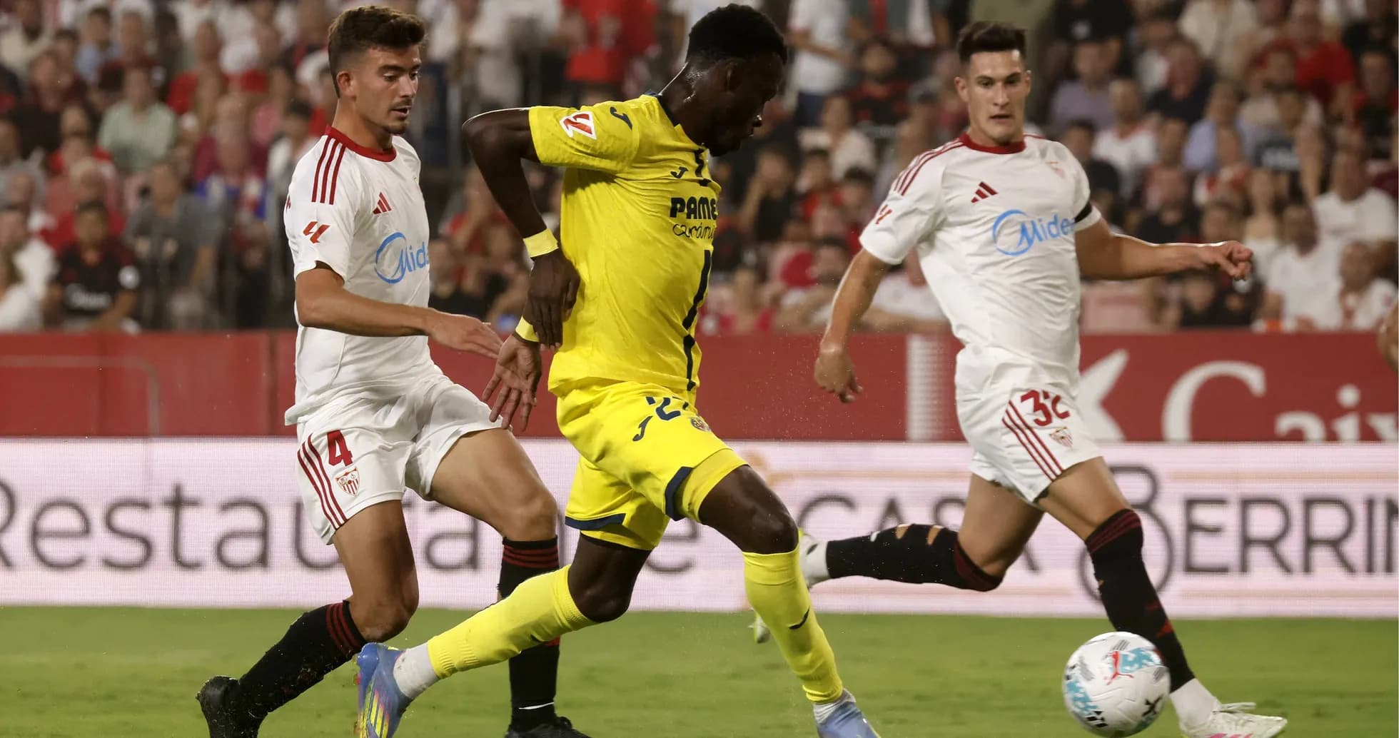 Jugadores compitiendo por el balón en partido Jugadores compitiendo por el balón en partido