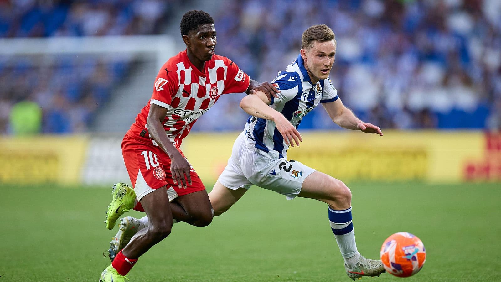 Jugador de Girona persiguiendo a jugador de Real Sociedad Jugador de Girona persiguiendo a jugador de Real Sociedad
