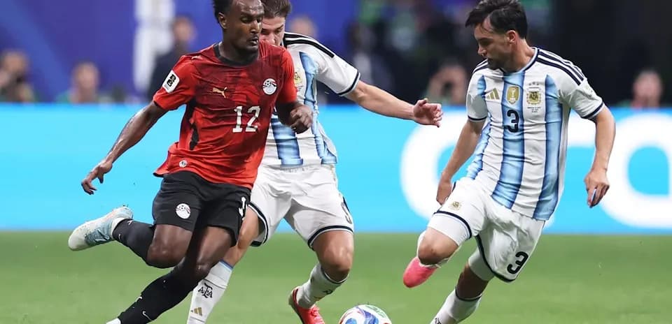 Jugador de Egipto driblando entre dos argentinos en partido Jugador de Egipto driblando entre dos argentinos en partido