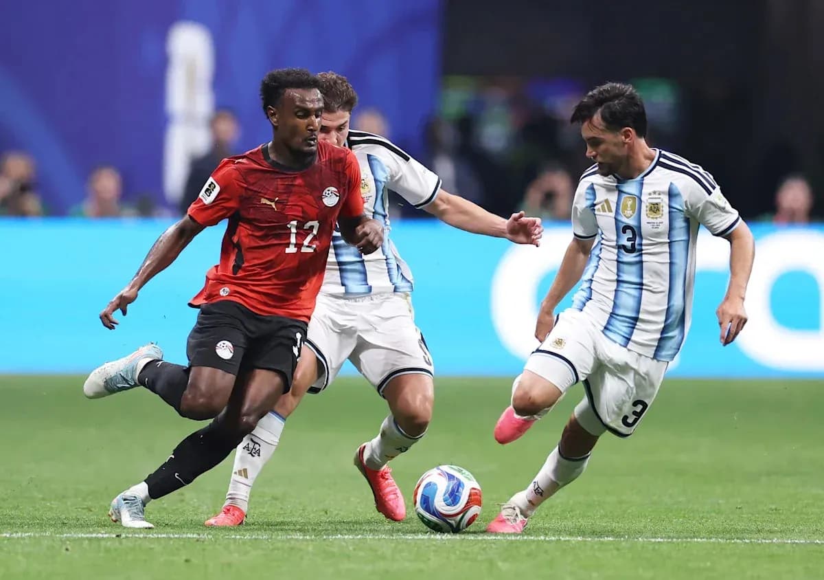 Jugador de Egipto driblando entre dos argentinos en partido Jugador de Egipto driblando entre dos argentinos en partido