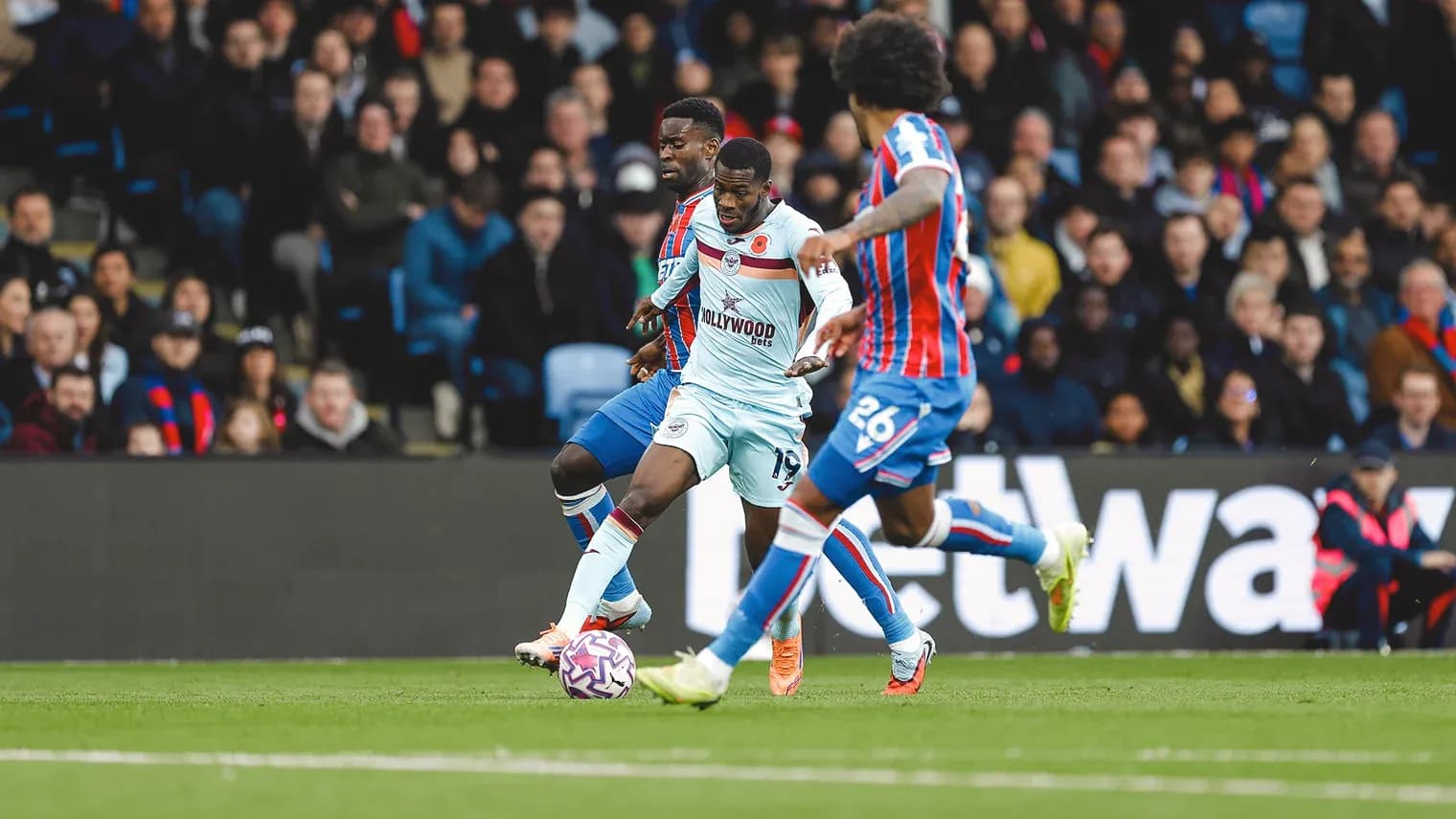 Jugador de Brentford compitiendo con rival de Crystal Palace Jugador de Brentford compitiendo con rival de Crystal Palace