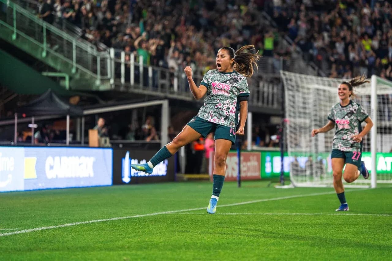 Jugadora celebra gol en partido de fútbol femenino Jugadora celebra gol en partido de fútbol femenino